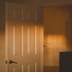 A 6 panel white door in warm orange lighting