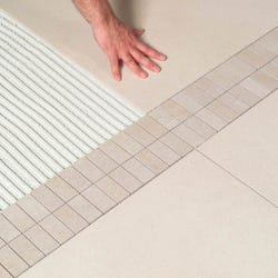 person tiling a bathroom floor